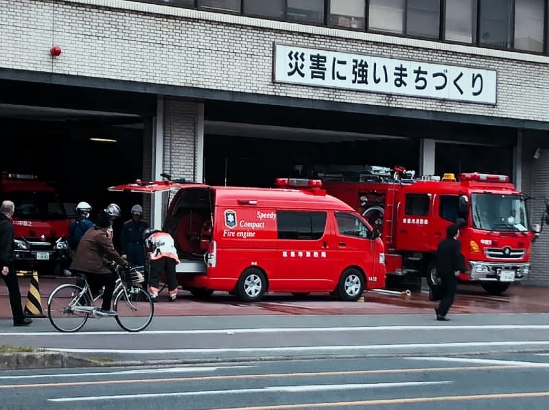Photograph of fire engines at a Tokyo fire station, seen from across a nearly empty road